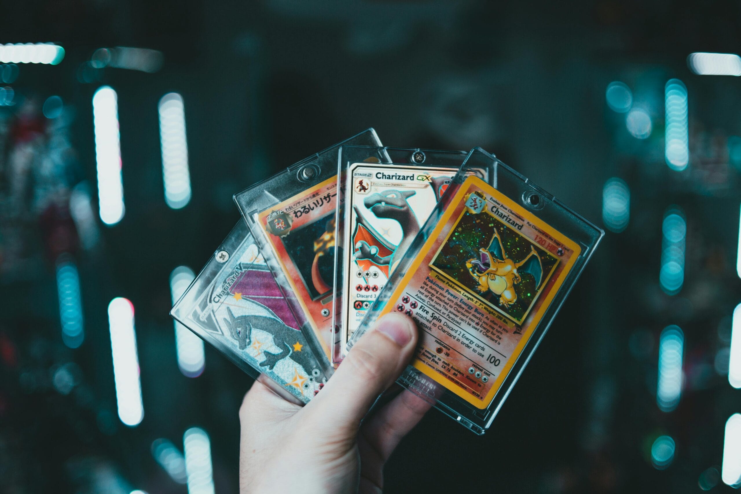 pexels-photo-9661252-9661252 - Gaulier Automobile A hand holds collectible Charizard Pokemon cards with a blurred bokeh background. Perfect for trading card enthusiasts.